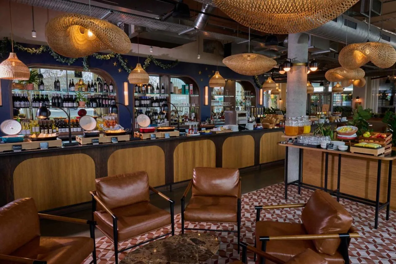 a bar in a restaurant with chairs and a counter at Turing Locke Cambridge in Cambridge