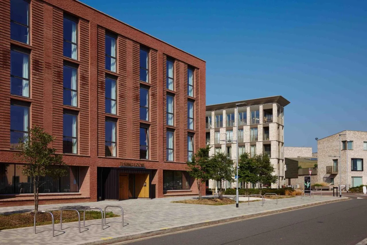 a large red brick building on a city street at Turing Locke Cambridge in Cambridge